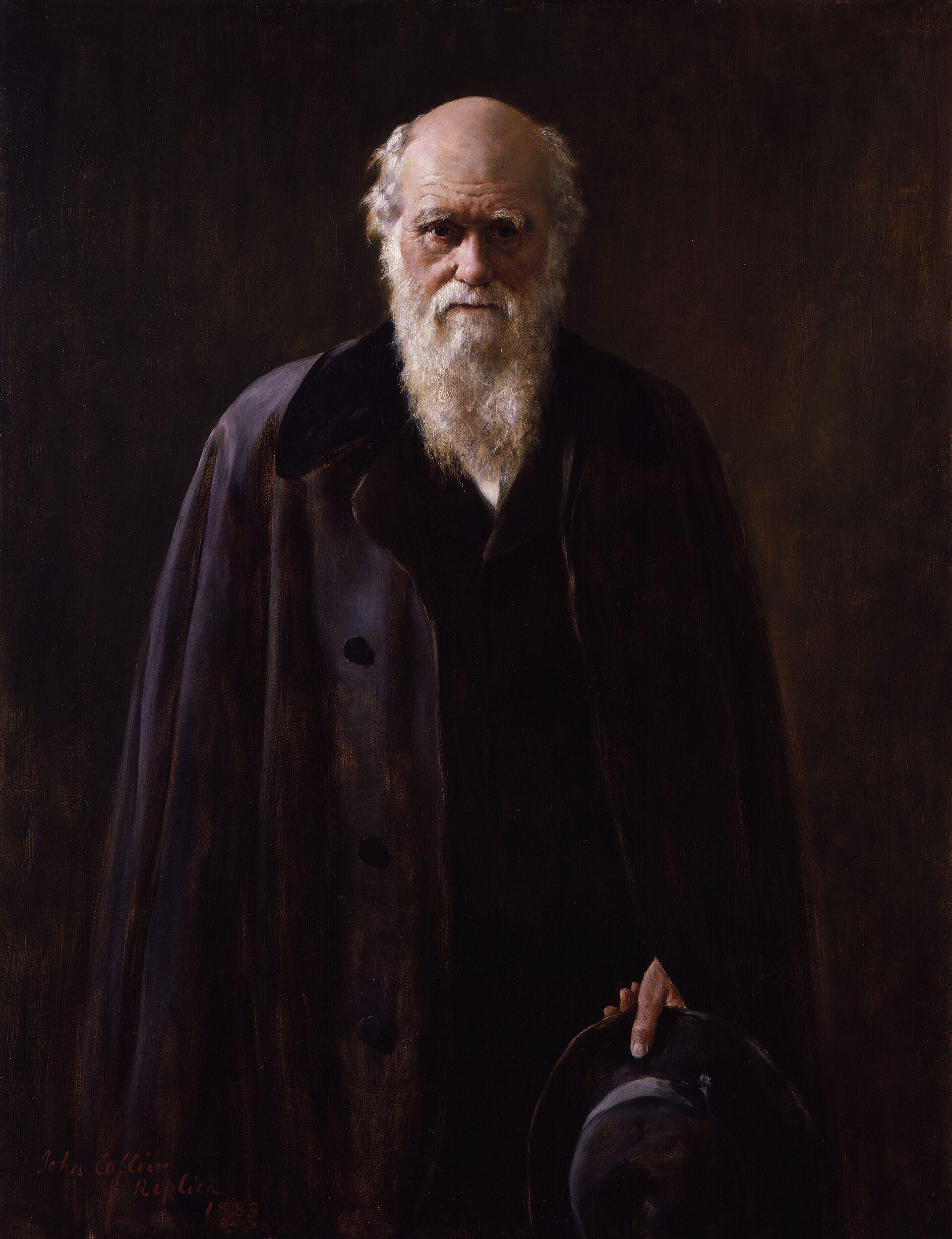 Portrait of Charles Darwin with a long white beard, wearing a dark cloak and holding a hat