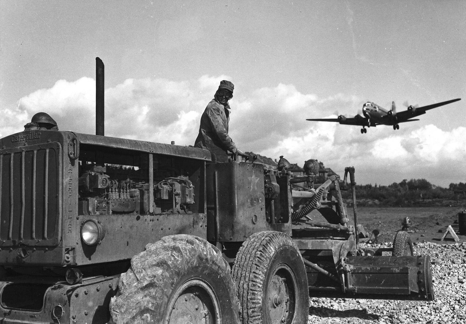A C-54 Skymaster landing on the old runway at Tempelhof Airport during the Berlin Airlift while construction work continues