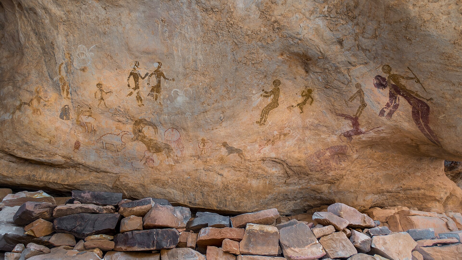 Prehistoric rock paintings of human figures, cattle and animals at Tanzoumaitak in Tassili n'Ajjer, Algeria