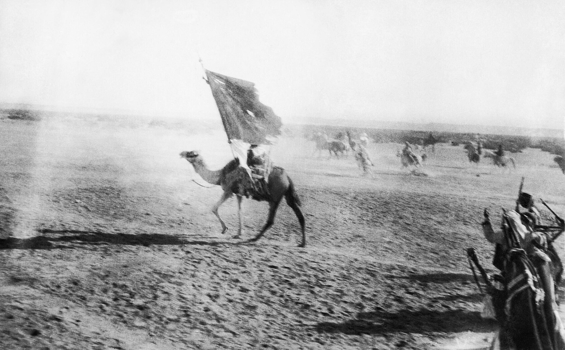 A flag bearer mounted on a camel leading the entry into Aqaba during the Arab Revolt, July 1917
